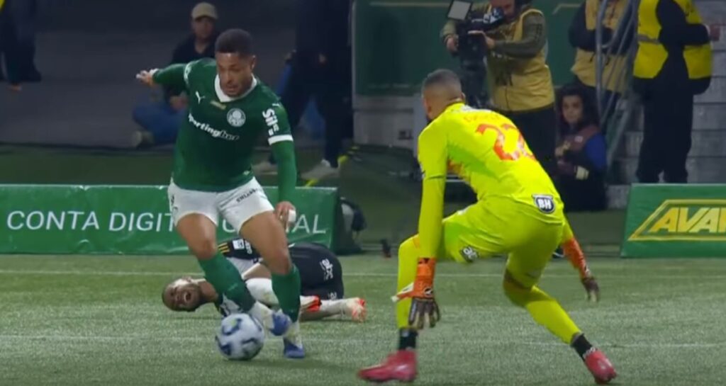 Penyerang Palmeiras menggiring bola melewati kiper Atletico Mineiro dalam laga Palmeiras vs Atletico Mineiro di Allianz Parque.
